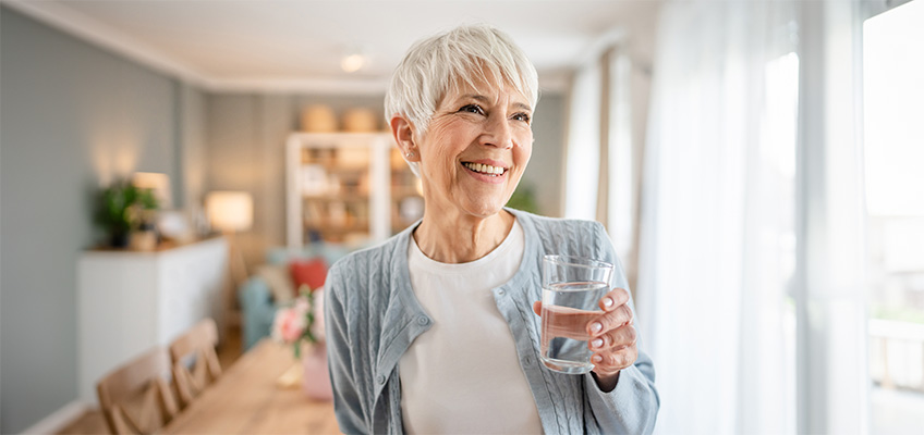 Smiling woman holding a glass of water